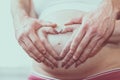 Couple with hands in a heart shape on pregnant belly Royalty Free Stock Photo