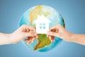 Couple hands holding green house over earth globe Royalty Free Stock Photo