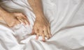 Couple hands pulling white sheets in ecstasy, orgasm. Concept of passion. Orgasm. Erotic moments. Intimate concept. Sex