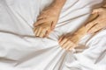 Couple hands pulling white sheets in ecstasy, orgasm. Concept of passion. Oorgasm. Erotic moments. Intimate concept. Sex Royalty Free Stock Photo