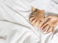Couple hands pulling white sheets in ecstasy, orgasm. Concept of passion. Orgasm. Erotic moments. Intimate concept. Sex