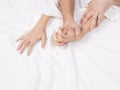 Couple hands pulling white sheets in ecstasy, orgasm. Concept of passion. Orgasm. Erotic moments. Intimate concept. Sex