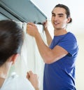 Couple hangs curtains on window Royalty Free Stock Photo