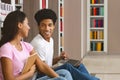 Couple of happy black students with laptop networking in library Royalty Free Stock Photo