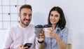 Couple of happy colleagues talking at the office with cups of coffee. Businessman and businesswoman drinking coffee Royalty Free Stock Photo