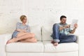 Couple with happy husband using internet app on digital tablet pad ignoring bored and sad wife