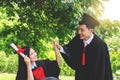 Couple happy smiling graduates, Woman students friends in graduation gowns holding diplomas and congratulate each other Royalty Free Stock Photo