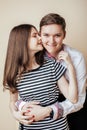 Couple of happy smiling teenagers students, warm colors having a kiss, lifestyle people concept