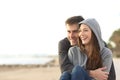 Couple of happy teens looking away on the beach