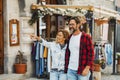 Couple of happy young adult people enjoy shopping and tourist outdoor leisure activity in the street. Man and woman enjoy walking