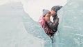 Couple has fun during winter walk against background of ice of f