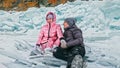 Couple has fun during winter walk against background of ice of f