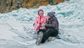 Couple has fun during winter walk against background of ice of f