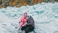 Couple has fun during winter walk against background of ice of f