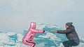 Couple has fun during winter walk against background of ice of f