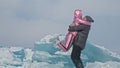 Couple has fun during winter walk against background of ice of frozen lake. Lovers lie on clear ice, have fun, kiss and Royalty Free Stock Photo