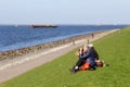 Couple enjoys a picknick at the and the panorama of the lake IJsselmeer, Flevoland, Netherlands