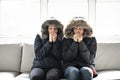 Couple have cold on the sofa at home with winter coat