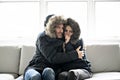 Couple have cold on the sofa at home with winter coat Royalty Free Stock Photo