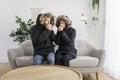 Couple have cold on the sofa at home with winter coat Royalty Free Stock Photo