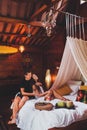 Couple having breakfast in bed in traditional indian wooden house. Hippie style