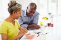 Couple Having Breakfast And Reading Magazine In Kitchen Royalty Free Stock Photo