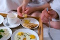Couple having a breakfast together in bed in hotel, wooden tray closeup. Royalty Free Stock Photo