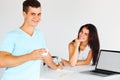 Couple having coffee near laptop, smiling at camera. Focus on th Royalty Free Stock Photo