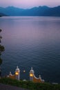 Romantic scenery of the couple having dinner under lanterns and enjoying magnificent view of Lake Como in Varenna, Italy. Royalty Free Stock Photo