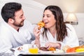 Couple having fun at breakfast in hotel room. Royalty Free Stock Photo