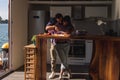 Couple having fun while cutting vegetables in the river house