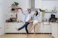 Couple having fun while house-keeping apartment together. Happy young couple doing home chores, singing and having fun Royalty Free Stock Photo