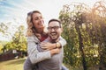 Couple having fun man giving piggyback to woman in park Royalty Free Stock Photo