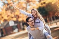 Couple having fun man giving piggyback to woman in park Royalty Free Stock Photo