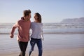 Couple Having Fun Running Along Winter Beach Together Royalty Free Stock Photo