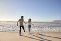 Couple Having Fun Running Along Winter Beach Together Royalty Free Stock Photo