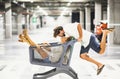 Couple having fun with shopping cart at parking garage, Husband kissing his carefree wife sitting inside shopping trolley. Couple Royalty Free Stock Photo