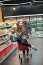 Couple having fun with the shopping cart in the supermarket Royalty Free Stock Photo