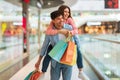 Couple Having Fun Shopping, Man Carrying Woman Piggyback In Mall Royalty Free Stock Photo