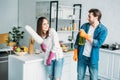 couple having fun with spray bottle and dust brush during