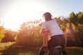 Couple having fun in spring forest. Man rides his girlfriend on back at sunset. Guys chilling out Royalty Free Stock Photo