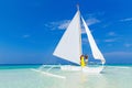 Couple having fun on tropical beach on the sailboat. Summer vacation concept. Royalty Free Stock Photo