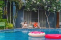 Couple having goodtime together on summer vacation in resort and hotel garden beside pool