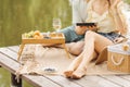 Couple is having great time on romantic picnic, sitting barefoot on beach and enjoying wine and sweets . Sweet life. Rest and Royalty Free Stock Photo