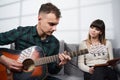 Couple playing guitar, reading a book Royalty Free Stock Photo