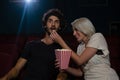 Couple having popcorn while watching movie in theatre Royalty Free Stock Photo