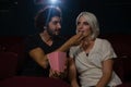 Couple having popcorn while watching movie in theatre Royalty Free Stock Photo