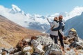 Couple having a rest on Everest Base Camp trekking route near Dughla 4620m. Backpackers left Backpacks, embracing and enjoying Royalty Free Stock Photo