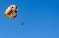 A couple having a ride with a colorful parasail towed by a boat