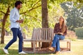 Couple Having Socially Distanced Meeting In Outdoor Park During Health Pandemic